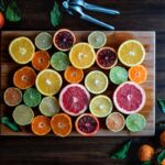 assorted sliced citrus fruits on brown wooden chopping board